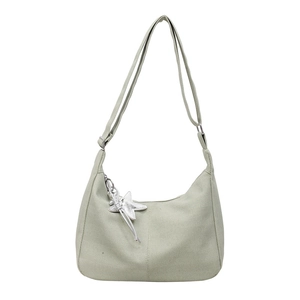 Light green crescent tote bag with herringbone knit texture and silver star charm