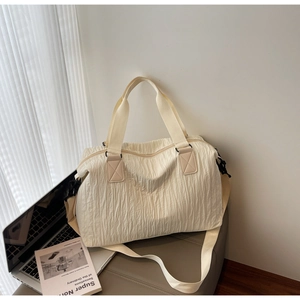 Détail du sac cabas beige plissé avec poignées en toile et bandoulière réglable