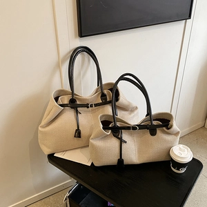 Set of two beige canvas tote bags in large and medium sizes with black leather handles