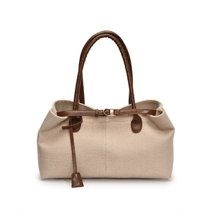 Beige canvas tote bag with brown leather trim and gold buckles for summer travel