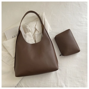 Close-up of deep brown leather tote bag set with matching pouch on white background