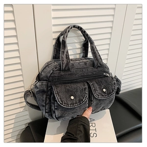 Detail of vintage denim crossbody bag with dual handles and metal buckle pockets