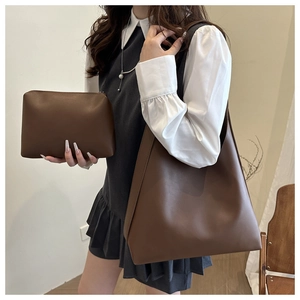 Detail of dark brown leather tote bag set including a large shoulder bag and small pouch