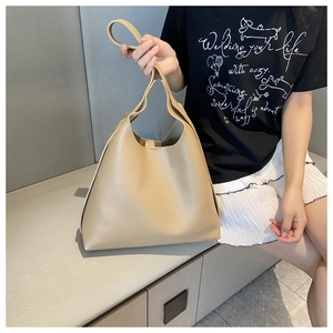 Close-up of the large khaki tote bag showing textured synthetic leather and spacious design