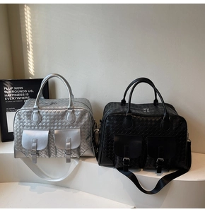 Detail of large woven crossbody bags in silver and black with dual top handles