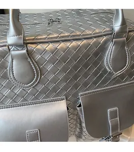 Macro detail of silver woven tote bag showcasing metallic texture and front pockets