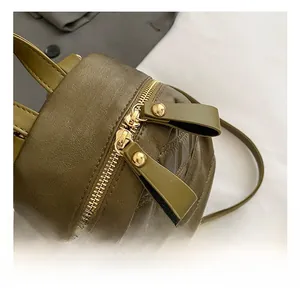 Detail of high-quality golden double metal zippers on green quilted diamond pattern bag