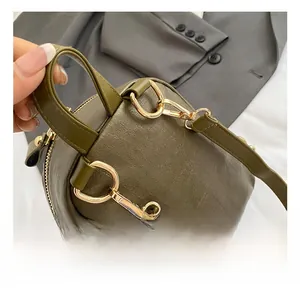 Close-up of golden metal swivel hook and hardware on green quilted leather backpack