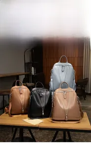 Close-up of vintage faux leather backpacks with unique V-shaped zipper design in four colors