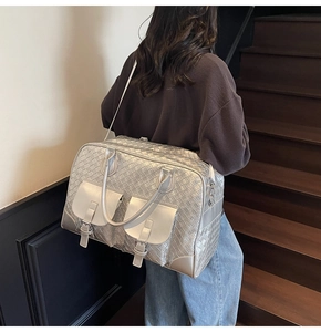 Silver woven tote bag with dual front pockets and shoulder strap shown on a model