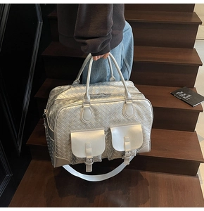 Detailed macro view of silver metallic woven texture bag with front pockets and buckles