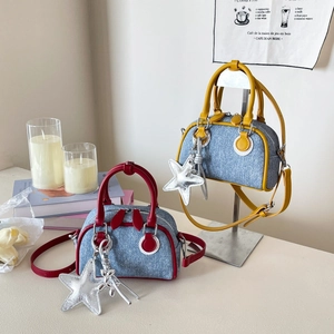 Détail de sacs Boston en denim avec finitions en cuir et breloques étoile en studio