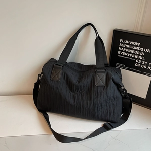 Sac à bandoulière plissé noir élégant avec grande capacité et sangle réglable sur marbre