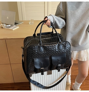 Macro detail of black woven leather duffel bag on suitcase with silver buckle pockets