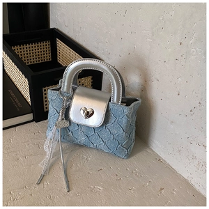 Detail of light blue denim mini bag with silver leather flap and heart-shaped metal lock