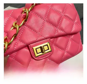 Close-up of pink quilted leather bag featuring a gold metal clasp and chain strap detail