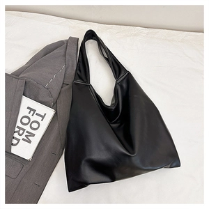 Close-up of a black oversized tote bag with a soft faux leather texture for daily commuting