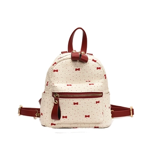Mini cream backpack with red bow and polka dot print featuring golden zippers