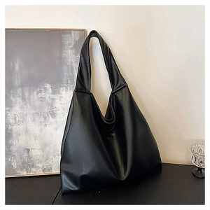 Detailed view of the smooth black leather texture on this minimalist large tote bag