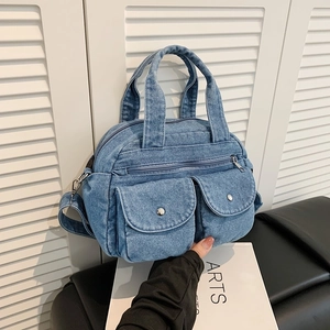 Vintage light blue denim crossbody bag with dual front pockets and metal buckle details