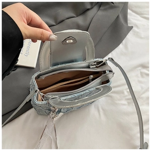 Detail view of denim handbag interior featuring silver lining and heart shaped metal lock