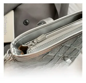 Dettaglio della borsa a secchiello in denim blu con cerniera argentata e chiusura