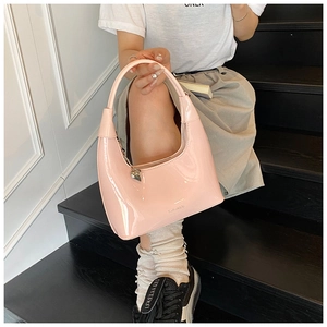 Pink patent leather hobo bag with a heart pendant and sleek glossy finish