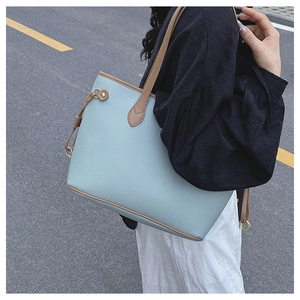 Detail view of light blue lychee pattern tote bag with brown leather shoulder straps