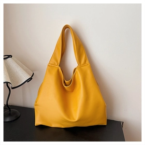 Minimalist ginger yellow large capacity hobo tote bag displayed on a sleek black surface