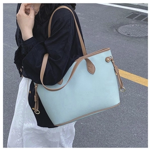 Close-up of mint blue tote bag with litchi texture and brown contrast straps