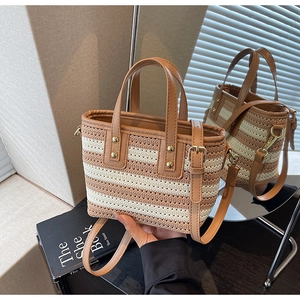 Detail of striped woven bucket bag featuring brown leather straps and gold rivet accents