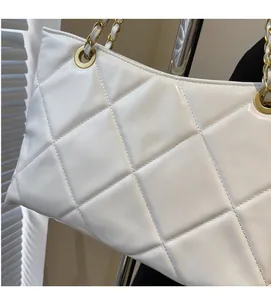 Dettaglio della borsa shopper trapuntata bianca con finitura lucida e catena d'oro