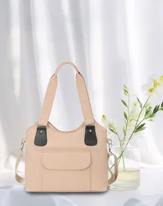 Detail of beige canvas tote with front flap pocket and black leather trim accents