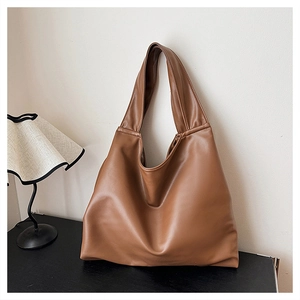 Macro shot of large caramel brown tote bag with premium faux leather texture and wide strap
