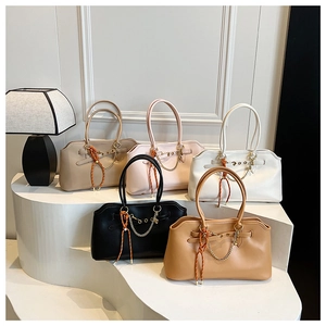 Detail view of large underarm bags in five colors with scalloped edges and chain details