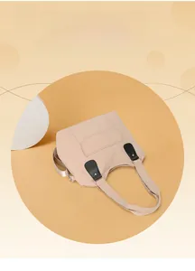 Detail of light beige nylon tote bag with black leather hardware and outer pocket