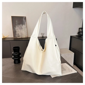 Detailed view of cream PU leather tote bag with soft texture and wide shoulder strap