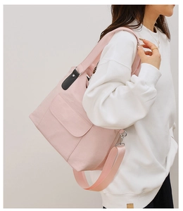 Detail view of pink large canvas tote bag with front pocket and thick shoulder strap