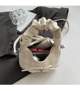 Dettaglio dell'interno spazioso della borsa a scacchi beige con oggetti di uso quotidiano