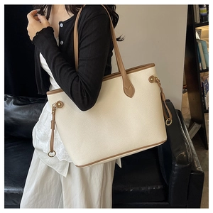 Litchi pattern detail on cream tote bag with brown straps and gold metal ring buckles