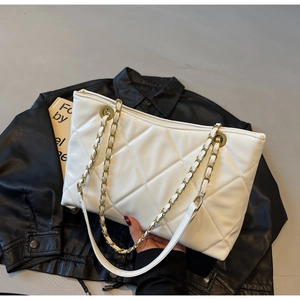 Dettaglio borsa tote bianca trapuntata con catena in metallo dorato e tracolla in pelle