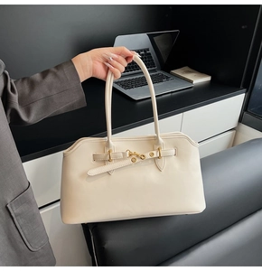 Dettaglio della borsa a spalla in similpelle crema con fibbia in metallo dorato elegante