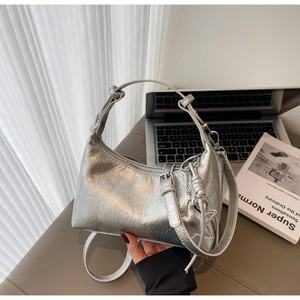Close-up of silver metallic crescent hobo bag featuring crinkled leather and star charm