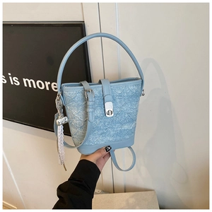 Détail du sac seau bleu clair montrant la texture denim et la boucle en métal argent