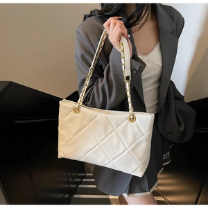 Dettaglio della borsa trapuntata bianca con catene dorate e elegante texture in ecopelle