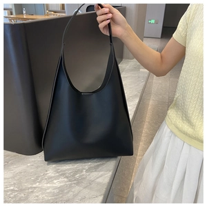 Detail of a black minimalist leather Hobo bag with spacious interior and wide shoulder strap