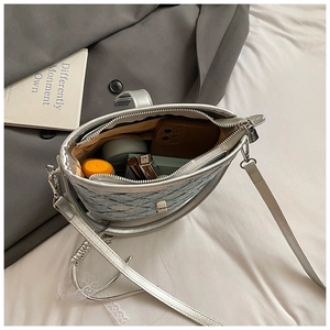 Détail du sac seau argenté montrant la texture matelassée et la capacité intérieure