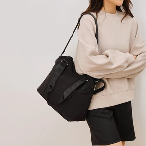 Minimalist black canvas tote bag with large capacity and adjustable crossbody strap