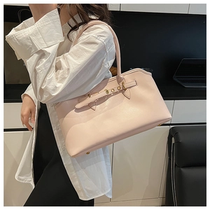 Dettaglio della borsa tote rosa chiaro con borchie dorate e tracolla per il lavoro