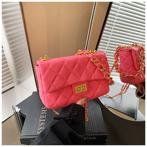 Hot pink quilted chain shoulder bag with gold twist lock in a stylish lifestyle setting